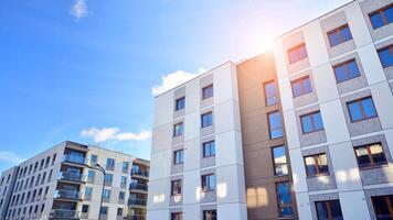 Modern apartment building in sunny day. Exterior, residential house facade. Residential area with modern, new and stylish living block of flats. photo