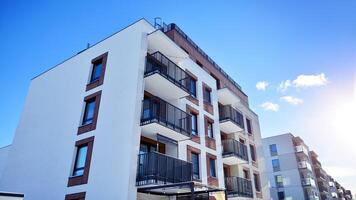 Modern apartment building in sunny day. Exterior, residential house facade. Residential area with modern, new and stylish living block of flats. photo