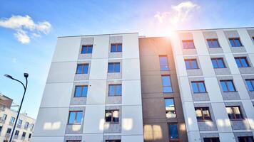 Modern apartment building in sunny day. Exterior, residential house facade. Residential area with modern, new and stylish living block of flats. photo