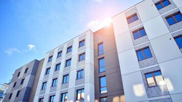 Modern apartment building in sunny day. Exterior, residential house facade. Residential area with modern, new and stylish living block of flats. photo