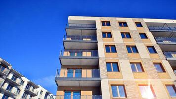 Modern apartment building in sunny day. Exterior, residential house facade. Residential area with modern, new and stylish living block of flats. photo