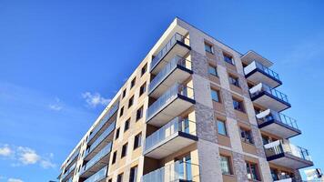 Modern apartment building in sunny day. Exterior, residential house facade. Residential area with modern, new and stylish living block of flats. photo