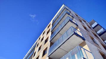 Modern apartment building in sunny day. Exterior, residential house facade. Residential area with modern, new and stylish living block of flats. photo