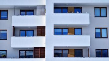 Modern apartment building in sunny day. Exterior, residential house facade. Residential area with modern, new and stylish living block of flats. photo