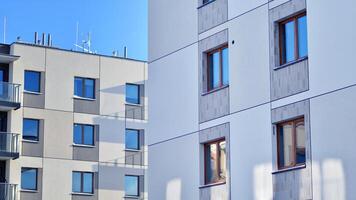 Modern apartment building in sunny day. Exterior, residential house facade. Residential area with modern, new and stylish living block of flats. photo