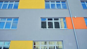 Multi-colored facades of the school with white window frames. photo