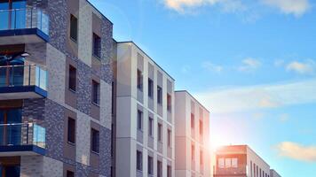 Modern apartment building in sunny day. Exterior, residential house facade. Residential area with modern, new and stylish living block of flats. photo