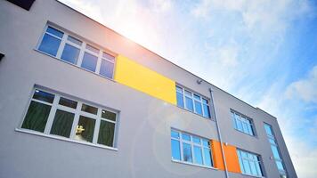 Multi-colored facades of the school with white window frames. photo