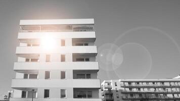 Fragment of the building's facade with windows and balconies. Modern apartment buildings on a sunny day. Facade of a modern residential building. Black and white. photo