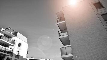 fragmento de el del edificio fachada con ventanas y balcones moderno Departamento edificios en un soleado día. fachada de un moderno residencial edificio. negro y blanco. foto