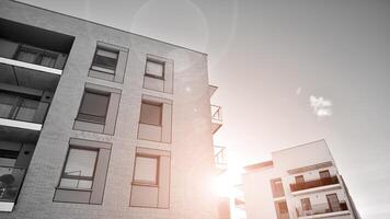 Fragment of the building's facade with windows and balconies. Modern apartment buildings on a sunny day. Facade of a modern residential building. Black and white. photo