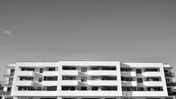 fragmento de el del edificio fachada con ventanas y balcones moderno Departamento edificios en un soleado día. fachada de un moderno residencial edificio. negro y blanco. foto