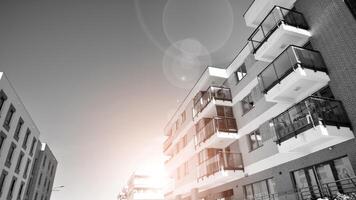Fragment of the building's facade with windows and balconies. Modern apartment buildings on a sunny day. Facade of a modern residential building. Black and white. photo