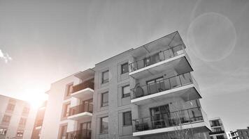 Fragment of the building's facade with windows and balconies. Modern apartment buildings on a sunny day. Facade of a modern residential building. Black and white. photo