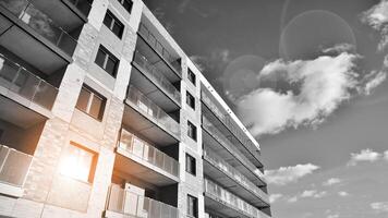 Fragment of the building's facade with windows and balconies. Modern apartment buildings on a sunny day. Facade of a modern residential building. Black and white. photo
