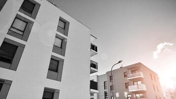 Fragment of the building's facade with windows and balconies. Modern apartment buildings on a sunny day. Facade of a modern residential building. Black and white. photo