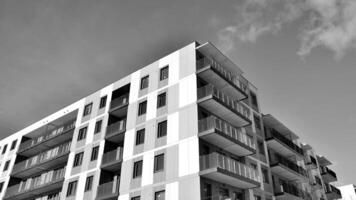 fragmento de el del edificio fachada con ventanas y balcones moderno Departamento edificios en un soleado día. fachada de un moderno residencial edificio. negro y blanco. foto