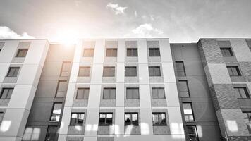 Fragment of the building's facade with windows and balconies. Modern apartment buildings on a sunny day. Facade of a modern residential building. Black and white. photo