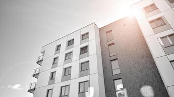 Fragment of the building's facade with windows and balconies. Modern apartment buildings on a sunny day. Facade of a modern residential building. Black and white. photo