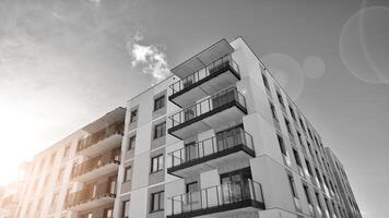 Fragment of the building's facade with windows and balconies. Modern apartment buildings on a sunny day. Facade of a modern residential building. Black and white. photo