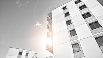 Fragment of the building's facade with windows and balconies. Modern apartment buildings on a sunny day. Facade of a modern residential building. Black and white. photo