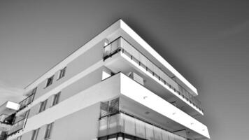 fragmento de el del edificio fachada con ventanas y balcones moderno Departamento edificios en un soleado día. fachada de un moderno residencial edificio. negro y blanco. foto