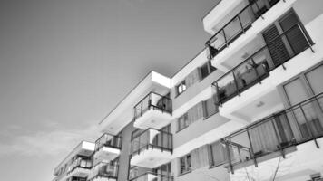 fragmento de el del edificio fachada con ventanas y balcones moderno Departamento edificios en un soleado día. fachada de un moderno residencial edificio. negro y blanco. foto