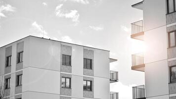 Fragment of the building's facade with windows and balconies. Modern apartment buildings on a sunny day. Facade of a modern residential building. Black and white. photo