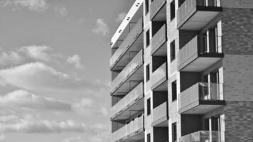 fragmento de el del edificio fachada con ventanas y balcones moderno Departamento edificios en un soleado día. fachada de un moderno residencial edificio. negro y blanco. foto