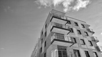 Fragment of the building's facade with windows and balconies. Modern apartment buildings on a sunny day. Facade of a modern residential building. Black and white. photo