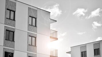 Fragment of the building's facade with windows and balconies. Modern apartment buildings on a sunny day. Facade of a modern residential building. Black and white. photo