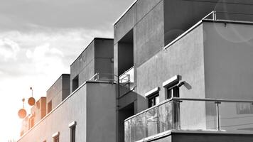 Fragment of the building's facade with windows and balconies. Modern apartment buildings on a sunny day. Facade of a modern residential building. Black and white. photo