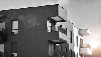 fragmento de el del edificio fachada con ventanas y balcones moderno Departamento edificios en un soleado día. fachada de un moderno residencial edificio. negro y blanco. foto