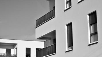 Fragment of the building's facade with windows and balconies. Modern apartment buildings on a sunny day. Facade of a modern residential building. Black and white. photo