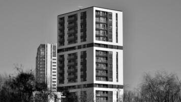 Fragment of the building's facade with windows and balconies. Modern apartment buildings on a sunny day. Facade of a modern residential building. Black and white. photo