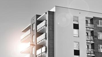 Fragment of the building's facade with windows and balconies. Modern apartment buildings on a sunny day. Facade of a modern residential building. Black and white. photo