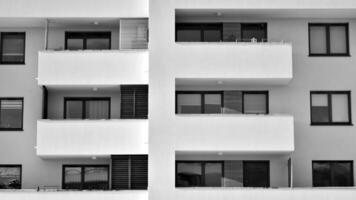 fragmento de el del edificio fachada con ventanas y balcones moderno Departamento edificios en un soleado día. fachada de un moderno residencial edificio. negro y blanco. foto