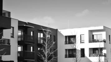 Fragment of the building's facade with windows and balconies. Modern apartment buildings on a sunny day. Facade of a modern residential building. Black and white. photo