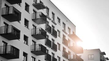 Fragment of the building's facade with windows and balconies. Modern apartment buildings on a sunny day. Facade of a modern residential building. Black and white. photo