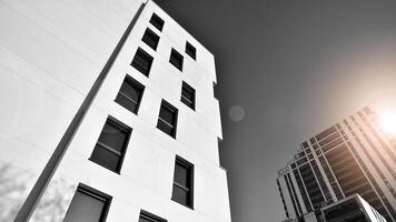 fragmento de el del edificio fachada con ventanas y balcones moderno Departamento edificios en un soleado día. fachada de un moderno residencial edificio. negro y blanco. foto