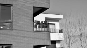 fragmento de el del edificio fachada con ventanas y balcones moderno Departamento edificios en un soleado día. fachada de un moderno residencial edificio. negro y blanco. foto