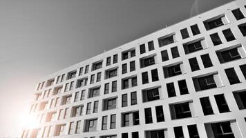 Fragment of the building's facade with windows and balconies. Modern apartment buildings on a sunny day. Facade of a modern residential building. Black and white. photo