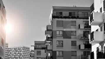 Fragment of the building's facade with windows and balconies. Modern apartment buildings on a sunny day. Facade of a modern residential building. Black and white. photo