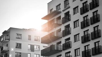 Fragment of the building's facade with windows and balconies. Modern apartment buildings on a sunny day. Facade of a modern residential building. Black and white. photo