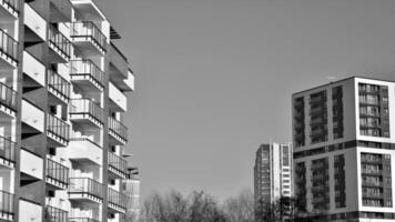 Fragment of the building's facade with windows and balconies. Modern apartment buildings on a sunny day. Facade of a modern residential building. Black and white. photo