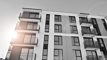 fragmento de el del edificio fachada con ventanas y balcones moderno Departamento edificios en un soleado día. fachada de un moderno residencial edificio. negro y blanco. foto