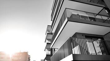 Fragment of the building's facade with windows and balconies. Modern apartment buildings on a sunny day. Facade of a modern residential building. Black and white. photo