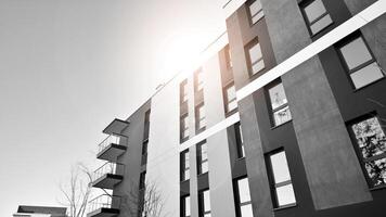 Fragment of the building's facade with windows and balconies. Modern apartment buildings on a sunny day. Facade of a modern residential building. Black and white. photo