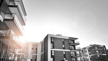 Fragment of the building's facade with windows and balconies. Modern apartment buildings on a sunny day. Facade of a modern residential building. Black and white. photo