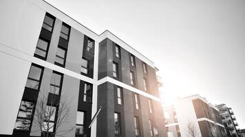 Fragment of the building's facade with windows and balconies. Modern apartment buildings on a sunny day. Facade of a modern residential building. Black and white. photo